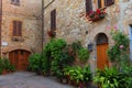 Pienza, Italy Ã¢â¬â May 27, 2017: Beautiful narrow street with sunlight and flowers in the village of Pienza, Italy Royalty Free Stock Photo